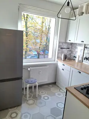 a kitchen with a refrigerator and a window at Angel Apartment near city centre in Vilnius