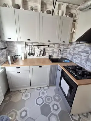 a kitchen with white cabinets and a stove top oven at Angel Apartment near city centre in Vilnius