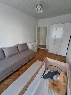 a living room with a couch and a teddy bear in a box at Angel Apartment near city centre in Vilnius