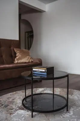 a black coffee table with books on it in a living room at Feliz Stay in Šiauliai