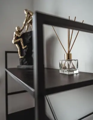 a table with a glass vase on a shelf at Feliz Stay in Šiauliai