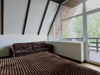 a bedroom with a bed and a large window at Kauno Marių Vilos in Samylai