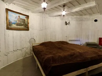 a bedroom with a bed with a painting on the wall at Kauno Marių Vilos in Samylai