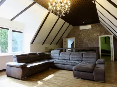 a living room with a couch and a chandelier at Kauno Marių Vilos in Samylai