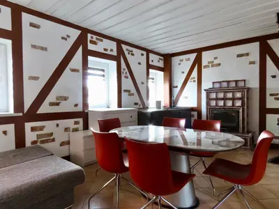 a dining room with a glass table and red chairs at Kauno Marių Vilos in Samylai