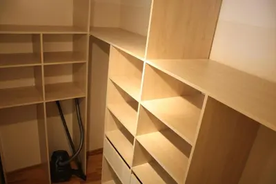 a closet with wooden shelves in a room at 2 bedroom old town apartment with parking in Vilnius