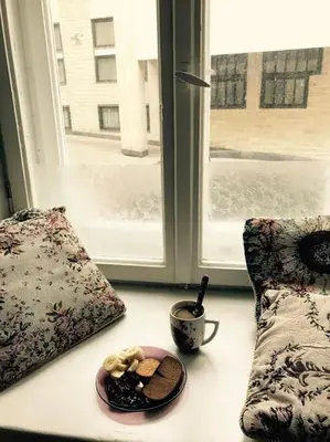 a table with a plate of food next to a window at 2 bedroom old town apartment with parking in Vilnius