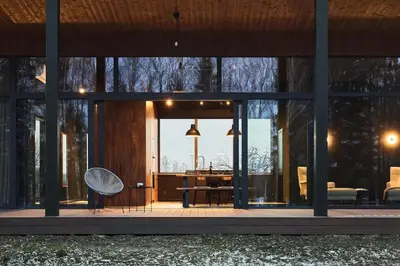 a glass house with a chair and a table at The Barn