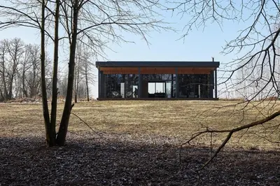a building in the middle of a field with a tree at The Barn