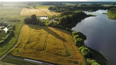 an aerial view of a field next to a river at The Barn