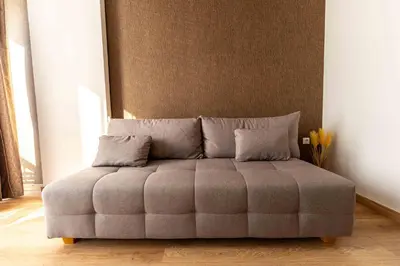 a tufted couch in a room with a wall at Sky Pool Escape Luxury Apartment in Druskininkai Center in Druskininkai