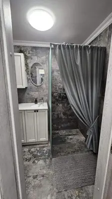 a bathroom with a shower with a sink and a mirror at Draugystės Apartments - Šiauliai Center in Šiauliai