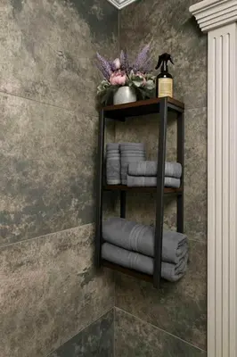 a black shelf with towels on a wall at Draugystės Apartments - Šiauliai Center in Šiauliai