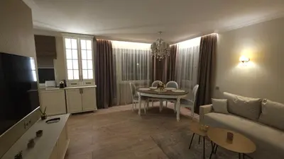 a living room with a couch and a table and a kitchen at Draugystės Apartments - Šiauliai Center in Šiauliai