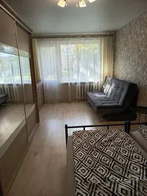 a living room with a couch and a chair at Vieno kambario butas Šiauliuose in Šiauliai
