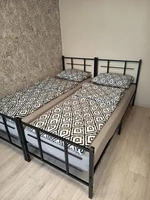 a bed with a black frame and pillows on it at Vieno kambario butas Šiauliuose in Šiauliai