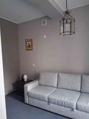 a living room with a couch and a chandelier at Šiluvos Svaja in Šiluva
