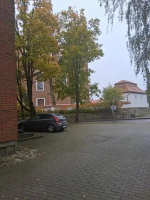 a car parked in a parking lot next to a building at Šiluvos Svaja in Šiluva