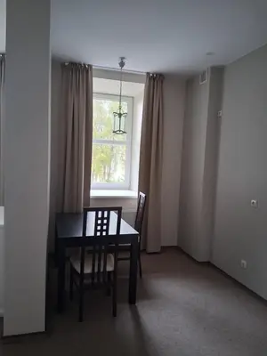 a dining room with a table and chairs and a window at Šiluvos Svaja in Šiluva