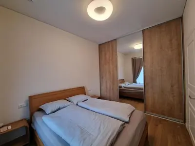 a small bedroom with a bed and a mirror at Vandens takas in Birštonas