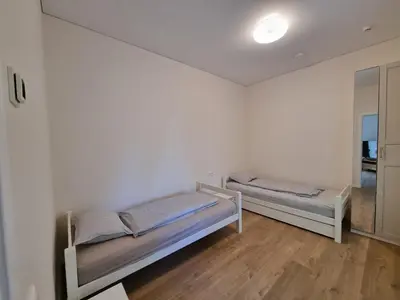 a white room with two beds in it at Vandens takas in Birštonas