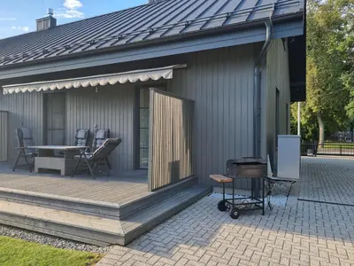 a wooden deck with a table and chairs on it at Vandens takas in Birštonas