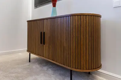 a wooden cabinet in the corner of a room at Central Stay Apartments in Šiauliai