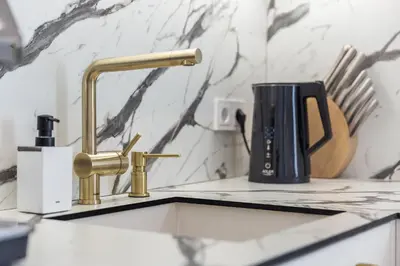 a kitchen counter with a sink and a faucet at Central Stay Apartments in Šiauliai