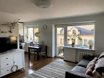 a living room with a couch and a table at Bright and cozy apartment in the city center with balcony in Šiauliai