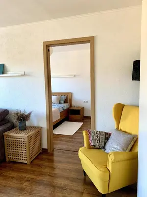 a living room with a mirror and a yellow couch at Bright and cozy apartment in the city center with balcony in Šiauliai