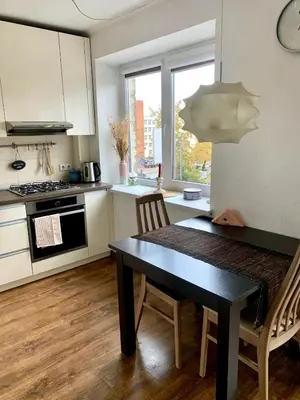 a kitchen with a black table and chairs in a room at Bright and cozy apartment in the city center with balcony in Šiauliai