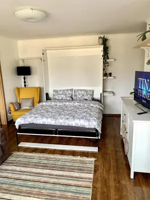 a bedroom with a large bed and a couch at Bright and cozy apartment in the city center with balcony in Šiauliai