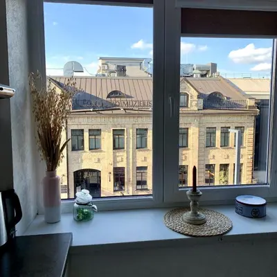 a window with a view of a large building at Bright and cozy apartment in the city center with balcony in Šiauliai