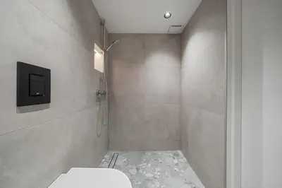 a bathroom with a toilet and a television on the wall at Golden loft in City centre Self check-in No 38 in Vilnius