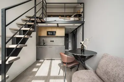 a small apartment with a staircase and a table at Golden loft in City centre Self check-in No 38 in Vilnius