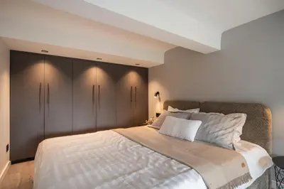 a bedroom with a large bed with gray cabinets at Golden loft in City centre Self check-in No 38 in Vilnius