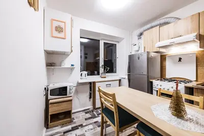 a kitchen with a table and a refrigerator at Cozy Apartment in Kaunas with Free Parking. in Kaunas