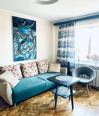 a living room with a blue couch and a table at Cozy Apartment in Kaunas with Free Parking. in Kaunas