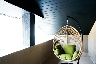 a swing with green pillows in a room at Svaja ApartHotel & SPA in Šiauliai