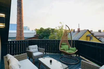 a balcony with chairs and a swing on a roof at Svaja ApartHotel & SPA in Šiauliai