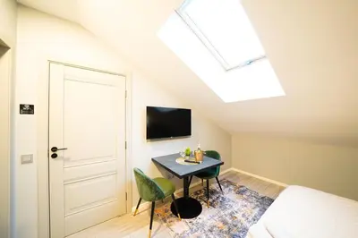 a bedroom with a table and a bed and a skylight at Svaja ApartHotel & SPA in Šiauliai