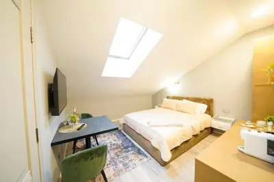 a bedroom with a bed and a desk and a tv at Svaja ApartHotel & SPA in Šiauliai