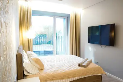 a bedroom with a bed with a tv and a window at Svaja ApartHotel & SPA in Šiauliai