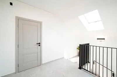 a white hallway with a door and a staircase at Svaja ApartHotel & SPA in Šiauliai