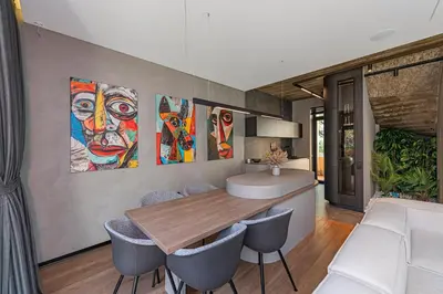 a dining room with a table and some paintings on the wall at Design 2 BD Apartment with Hot Tube by Domvia in Kaunas