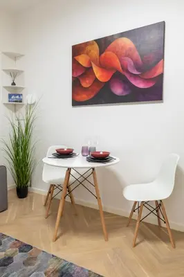 a table and a chair in a room with a painting at Old Town Retreat in Vilnius in Vilnius
