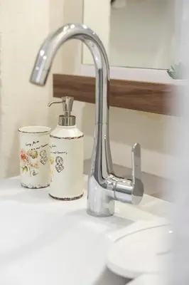 a bathroom sink with a faucet and two cups at Old Town Retreat in Vilnius in Vilnius
