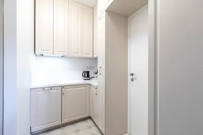 a small kitchen with white cabinets and a door at Old Town Retreat in Vilnius in Vilnius