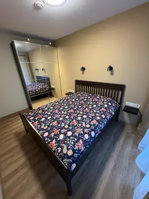 a bedroom with a bed with a floral quilt on it at Lovely Flat with Great Central Location Kaunas in Kaunas