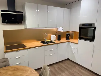 a kitchen with white cabinets and a sink and a table at Lovely Flat with Great Central Location Kaunas in Kaunas